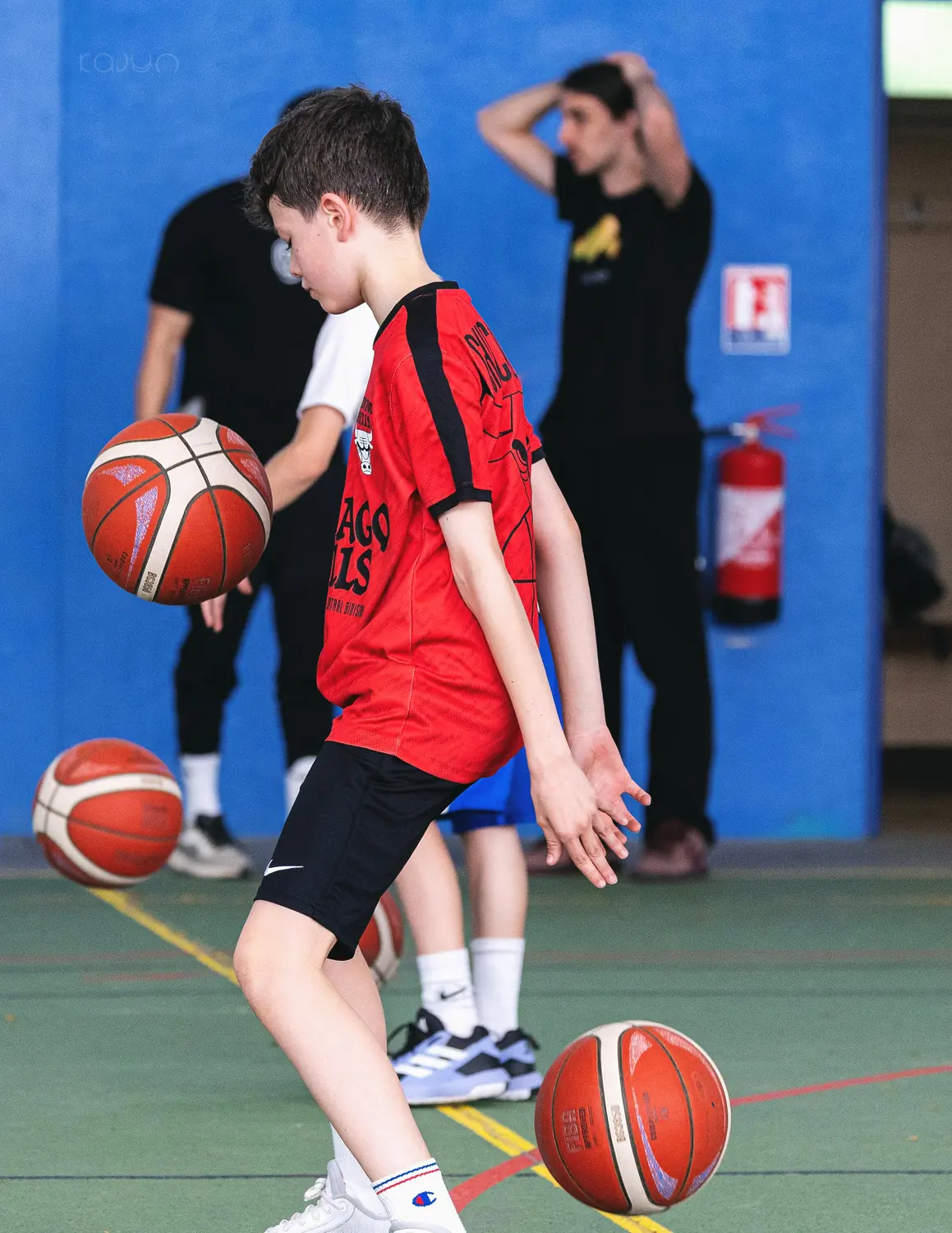 Un joueur dribble entre deux ballons sous le regard de Marc Mercier